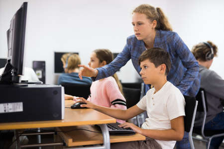 Teacher helping student with computer workの写真素材