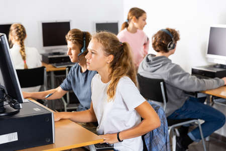 Portrait of a fifteen-year-old schoolgirl studying at a computerの写真素材