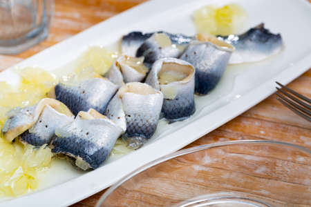 Salted pickled herring fish served on a ceramic plateの写真素材