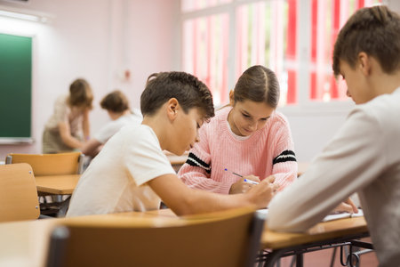 Schoolchilds working in groups at lesson