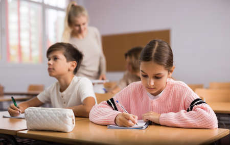 Group of school kids and teacher during lessonの写真素材