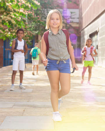 Portrait of little girl walking at schoolyardの写真素材
