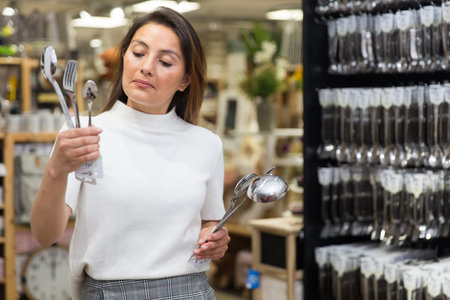 Woman chooses flatware in the shopの写真素材
