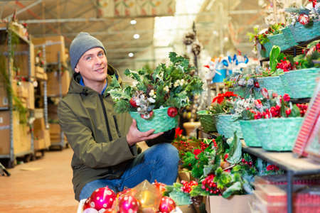 Man selecting christmas decorations in home goods storeの写真素材