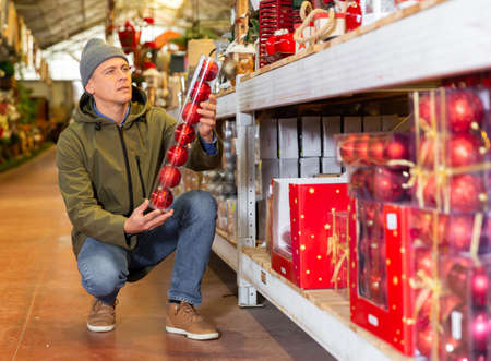 Man buying christmas balls on sale in storeの写真素材
