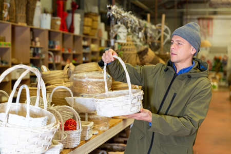 Man choosing wicker basket in decorative goods storeの写真素材