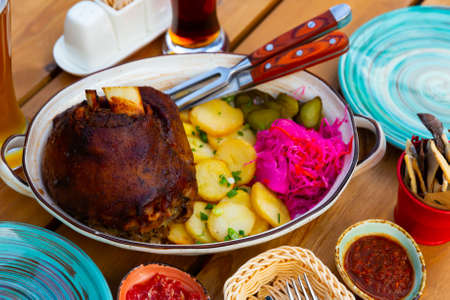 German pork hock with sliced potato and marinaded foodsの写真素材