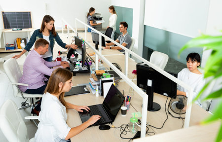 International business team working and communicating together in modern coworking space