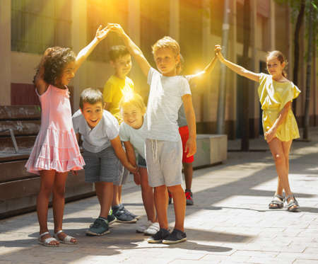Group of happy kids playing a game called trickle on the streetの写真素材