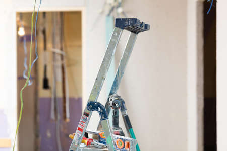 Stepladder with tools in empty room, renovation worksの写真素材