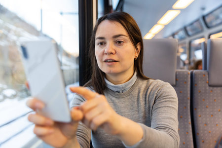 Woman taking pictures with her smartphone during train ride