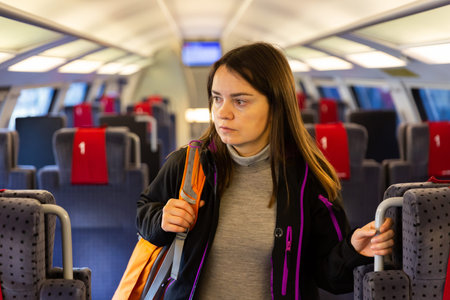 Woman standing between seats in train