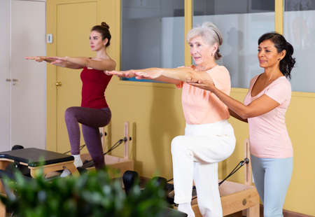 Active women perform exercises with outstretched armsの写真素材