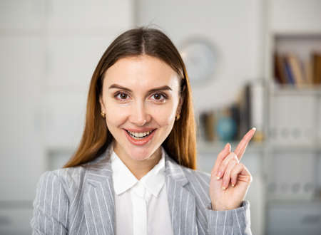 Business woman standing in office and pointingの写真素材
