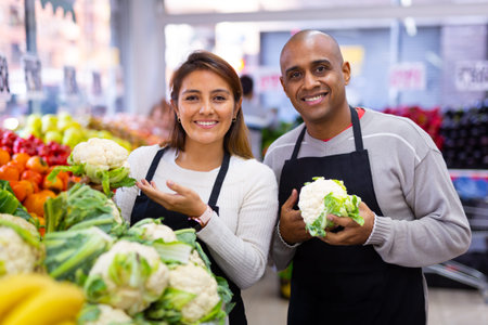 Friendly sellers posing in local supermarket