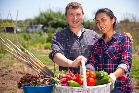Happy family of gardeners posing with harvest of vegetablesの写真素材