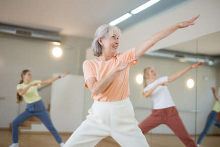 Mature woman with family enjoying active dances in dance studioの写真素材