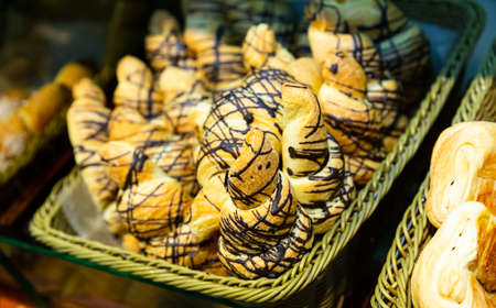 Closeup of various delicious sweet croissants presented on bakery showcaseの写真素材