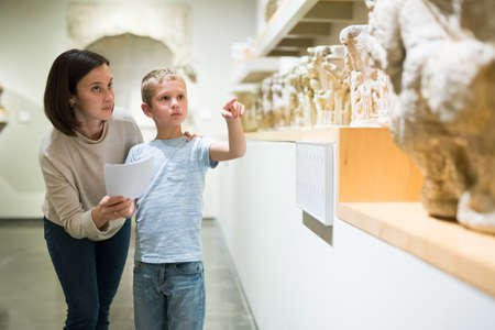 Woman and boy observing sculptures exhibitionの写真素材