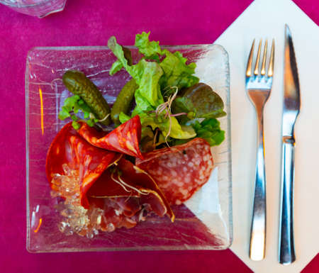 Platter of cold meats with lettuce and pickled cucumbers closeup. French cuisineの写真素材