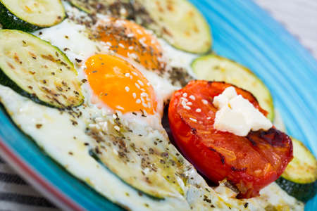 Image of fried eggs with zucchini and tomatoの写真素材