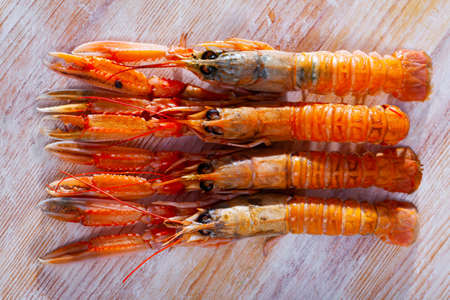 Raw Norway lobster on wooden tableの写真素材