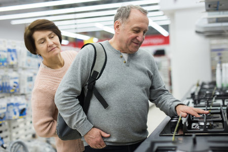 Happy spouses of mature age choose a gas stoveの写真素材