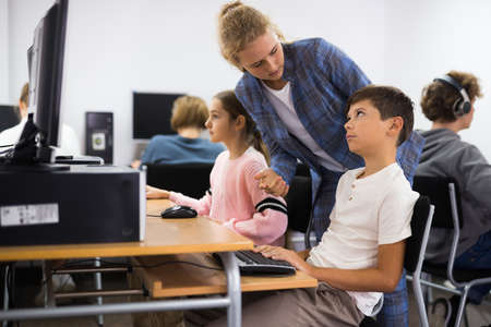 Teacher helping student with computer workの写真素材