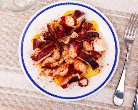 Boiled octopus tentacles with smoked paprika and potatoesの写真素材