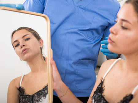 Doctor giving consultation about injection for lips to female patientの写真素材