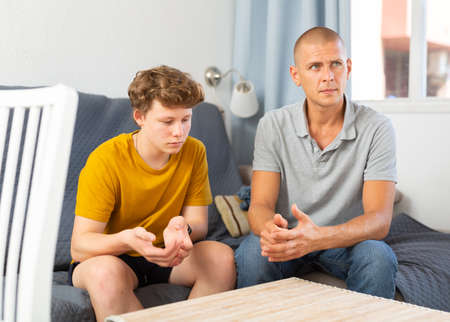 Father and his son sitting on sofaの写真素材