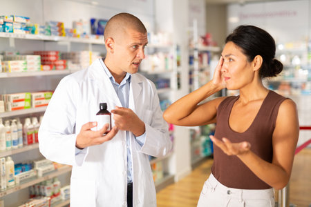 Woman buyer asks for help of pharmacist to choose medicine for headache closeupの写真素材