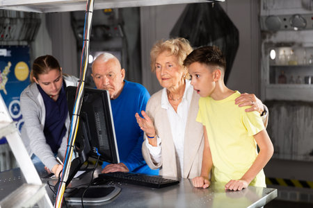 Kids and grandparents using computer in escape roomの写真素材