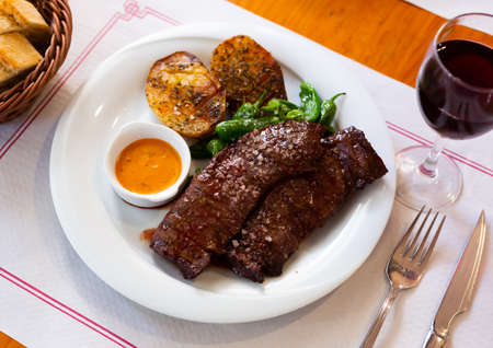 Grilled beef fillet with baked potato, green peppers and chimichurri sauceの写真素材