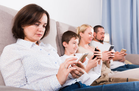 Modern family with smartphones at home