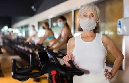 Mature woman posing after cycling at gymの写真素材