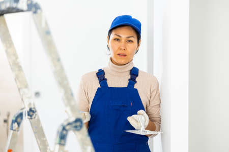 Portrait of professional female builder in process of repair at houseの写真素材
