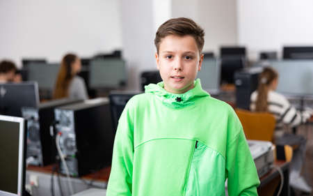 Tween schoolboy standing in computer class ready for lessonの写真素材
