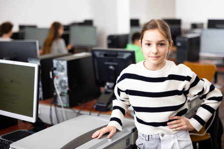 Teenager girl standing in computer class