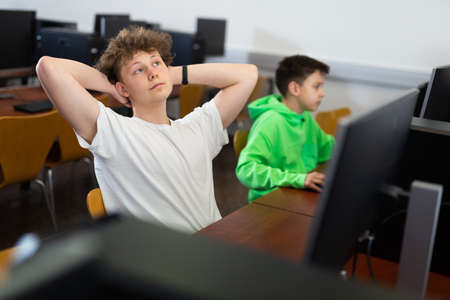 Teenage boy resting during computer science lessonの写真素材