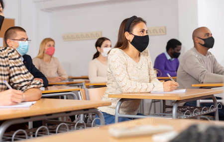 Woman in face mask studying with colleaguesの写真素材