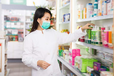 Chinese female druggist in protective facial maskの写真素材