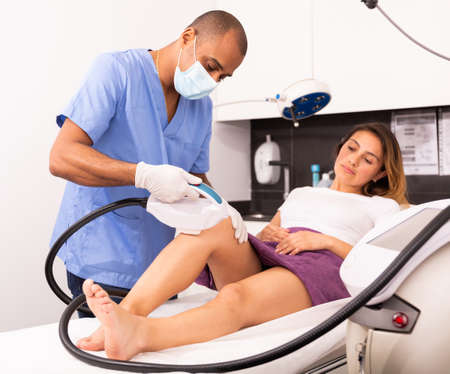 Cosmetologist and female client during laser hair removal procedureの写真素材