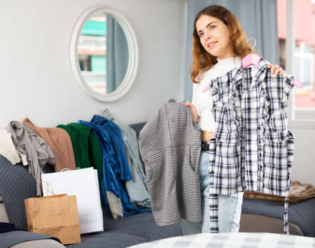 Young smiling woman choosing what to wearの写真素材