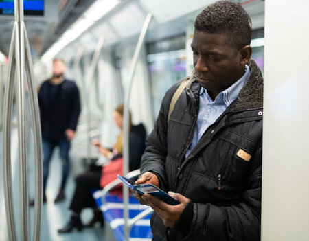 African American man with phone in metro carの写真素材
