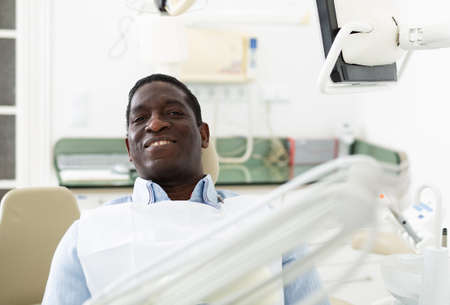 Smiling man in dental chair after surgeryの写真素材