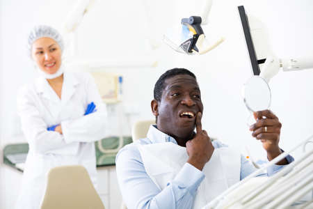 Cheerful African American after dental procedure in dentist officeの写真素材