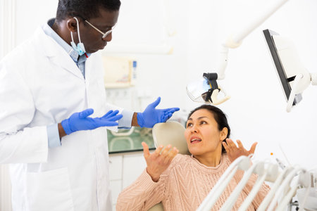 Woman talking with dentist about tooth problem in dental clinic