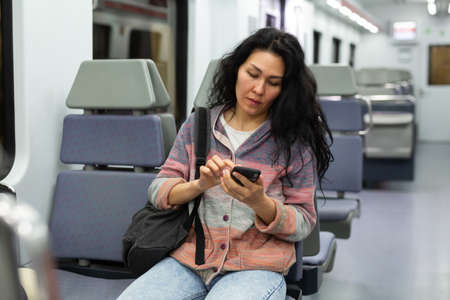 Portrait of asian woman traveler with backpack and suitcase in subway carの写真素材