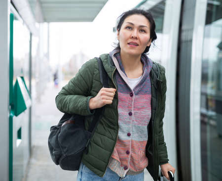 Woman traveler walking at modern tram stationの写真素材